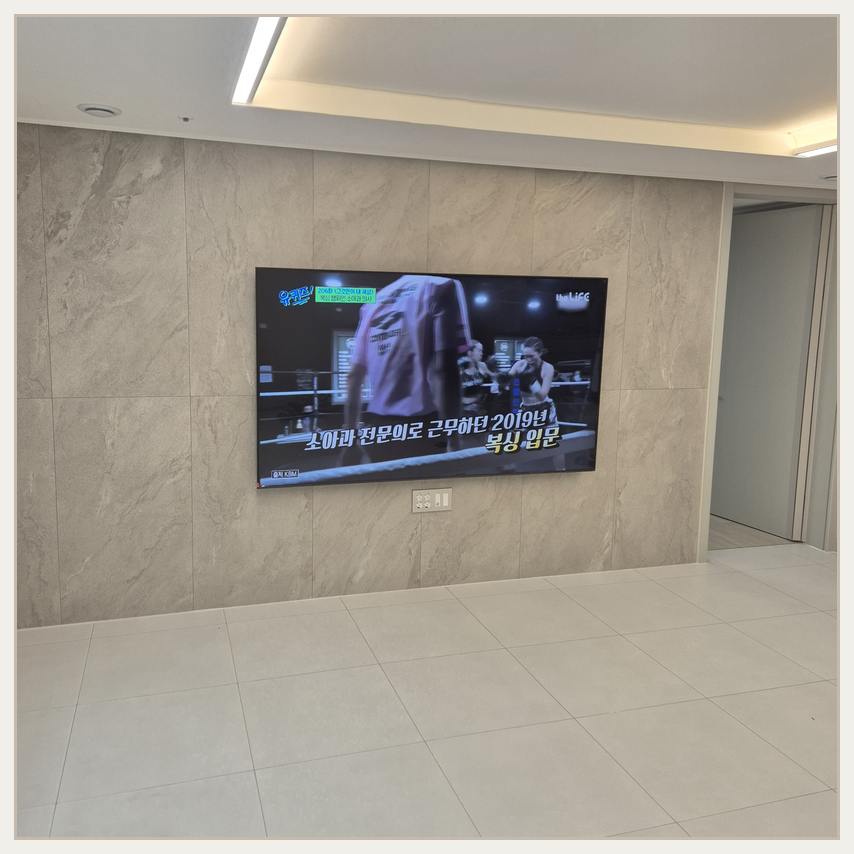 대형 TV 설치 전 주변 여유 공간을 검토하는 참고 이미지 · 벽면 보강 확인