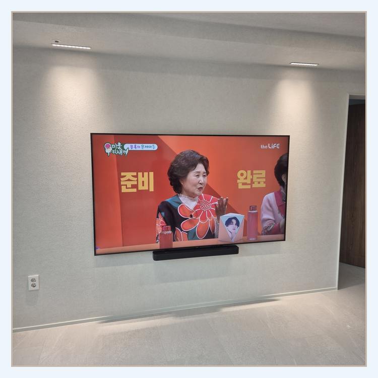 대형 TV 설치 전 주변 여유 공간을 검토하는 참고 이미지 · 무타공 방식 판단하기