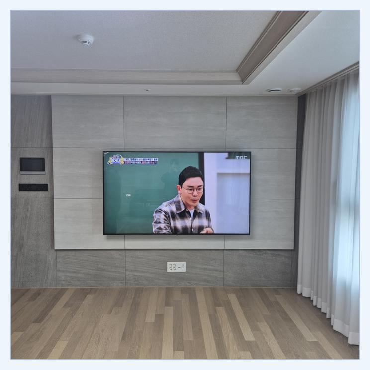 거실 화면 배치를 검토하는 벽걸이TV 설치 참고 사진 · 벽체 손상을 줄이려면